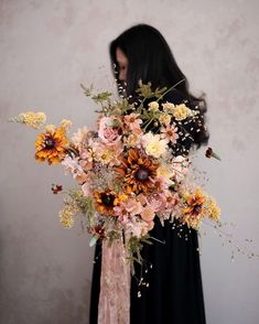 a woman holding a bouquet of flowers in front of her face