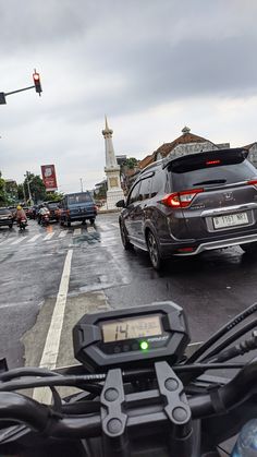 a car is stopped at an intersection on a rainy day with traffic lights in the background