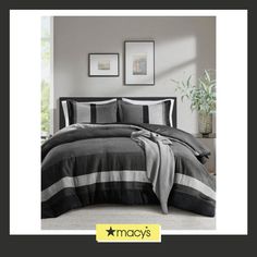 a black and white striped comforter set with two pictures on the wall behind it