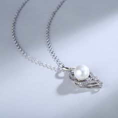 What's a better way to showcase your love for someone than with this charming piece? Set on a sterling silver ribbons, this pearl stands out and shines for all to see. Engrave your name or the name of a loved one to make it a unique gift.Chain Type: Weight: 2.1 gHeight: 30 mmMaterial: Plating Color: Silver Silver Pearl Necklace With Elegant Design For Gift, Pearl Necklaces For Anniversary, Exquisite Silver Pearl Jewelry, Elegant Pendant Necklace For Mother's Day, White Gold Pearl Necklace As A Gift, Sterling Silver Pearl Necklace For Wedding, Silver Necklace With Pearl Charm For Her, White Gold Pearl Necklace With Clavicle Chain For Gift, Silver Pendant Pearl Necklace With Elegant Design