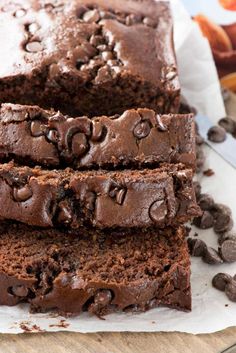 slices of chocolate banana bread on top of parchment paper next to sliced bananas and chocolate chips