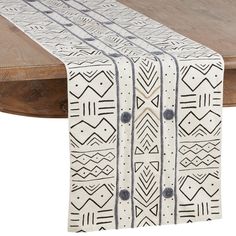 the table runner is decorated with black and white geometric designs on it, along with a wooden