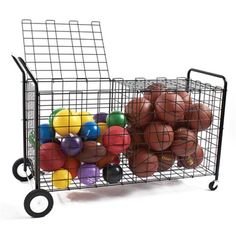 a metal basket filled with balls on top of a white table next to a black cart