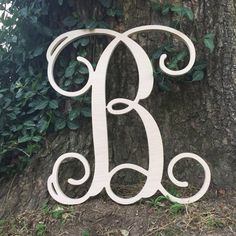 a white wooden monogram on the side of a tree