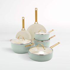 a set of pots and pans with gold handles