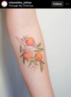 an orange tattoo on the arm of a woman's left arm, with flowers and leaves