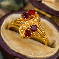 This charming antique ring features garnets and seed pearls and is crafted of 14k yellow gold. This ring is currently a size 3.75. Vintage Yellow Gold Garnet Birthstone Ring, Vintage Garnet Birthstone Ring In Yellow Gold, Vintage Gold Garnet Birthstone Ring, Vintage Garnet Birthstone Ring For Wedding, Victorian Red Cluster Ring For Wedding, Victorian Style Red Cluster Wedding Ring, Antique Ruby Ring, Seed Pearl Ring, Antique Jewelry Rings