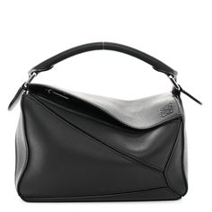 This is an authentic LOEWE Calfskin Small Puzzle Bag in Black. This elegant handbag is crafted of black calfskin leather. The bag features a rear zipper pocket, a black top handle, and polished silver hardware. This top zipper opens to a beige fabric interior with a patch pocket. Small Puzzle Bag, Loewe Puzzle Bag, Loewe Puzzle, Elegant Handbag, Puzzle Bag, Polish Silver, Beige Fabric, Black Top, Silver Hardware