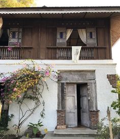 an old white house with wooden doors and windows