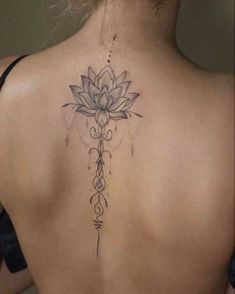 a woman's back with a lotus tattoo on it