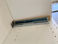 a piece of metal sitting on top of a white counter next to a window sill