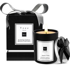 a candle with a black box next to it and a ribbon on the side that says yzoo