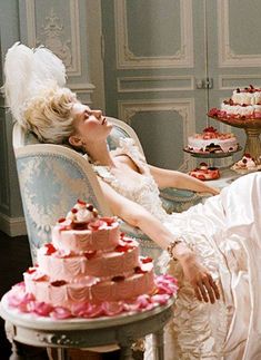 a woman laying in a chair next to a cake