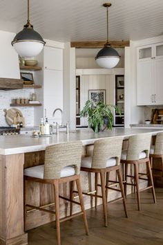 a kitchen island with four stools in front of it