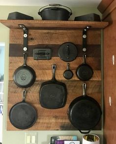 pots and pans are hanging on a wooden shelf