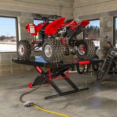 a red four wheeler on a trailer in a garage