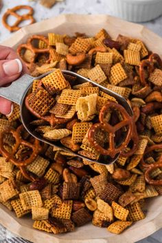 a bowl full of cheetos and pretzels with a spoon in it