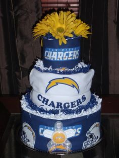 a three tiered cake with the chargers logo on it and yellow flowers in the center