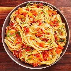 a bowl filled with pasta on top of a wooden table