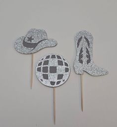 two cake toppers with hats on them and one has a stick in the shape of a disco ball