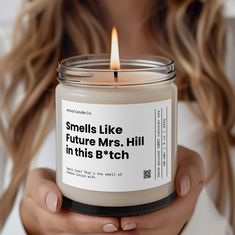 a woman holding a candle that says smells like future mrs hill in this b'tch