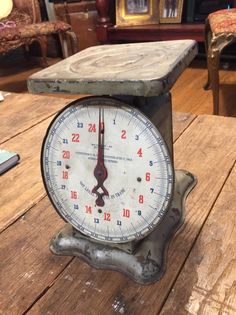 an old clock sitting on top of a wooden table