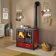 an old fashioned stove in the corner of a room with wood flooring and wall hangings