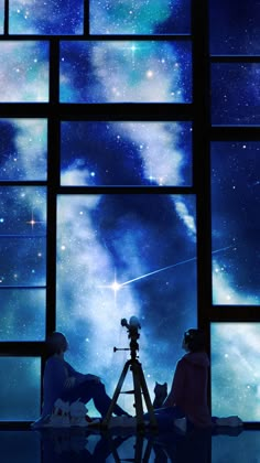 two people sitting in front of a window looking at the stars