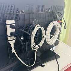 several cords are plugged into the back of a computer monitor with wires attached to it