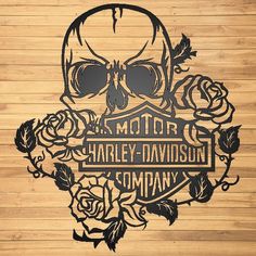 a wooden wall with a skull on it and roses around the edges that says harley davidson company