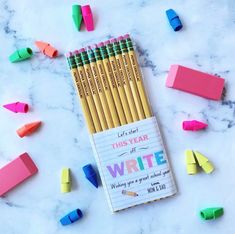 several colored pencils sitting next to each other on a marble surface with colorful crayons around them