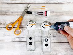 someone is making snowman salt and pepper shakers out of glass bottles with glue