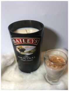 a bottle of bailey's next to a glass filled with liquid on a white surface