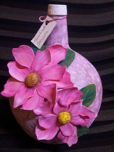 some pink flowers are in a vase on a black and white striped surface with a tag