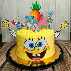 a spongebob cake on a plate with cartoon characters around the top and bottom