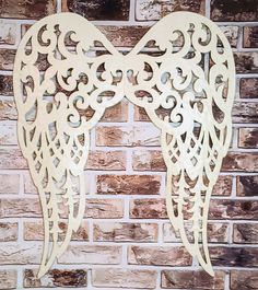 an angel wings cutout on a brick wall