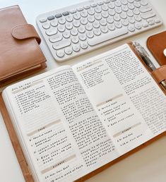 an open book sitting on top of a desk next to a keyboard