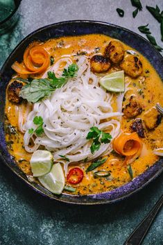 a bowl filled with noodles and shrimp on top of a table