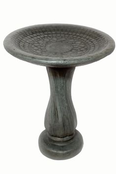 a metal pedestal with a circular design on the top and base, against a white background