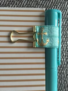 a blue and gold anchor clip on top of a notepad