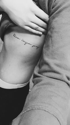 a woman's stomach with the words, i am sorry tattooed on her side