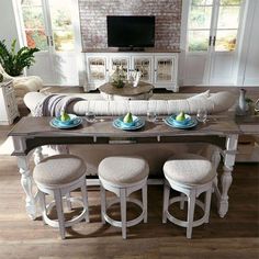 a living room filled with furniture and a flat screen tv on top of a wooden table