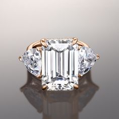 an emerald cut diamond ring with three pear shaped diamonds