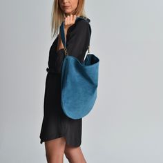 Anna suede bag in jeans blue. A beautiful  hobo bag which is ideal for every day use. Not just a shoulder bag but a statetment tote. It's loose minimalistic look makes it modern and unique.  Handmade in our studio from lux italian suede leather in jeans blue. A leather pocket made from the same leather is included at the interior. Metal details are available in gold or silver. The interior is unlined and has the same look as the exterior. Dimensions: Height, 40 cm (15,75 inches) Length, 41 cm (1 Hobo Shoulder Bag With Suede Lining, Trendy Blue Hobo Shoulder Bag, Blue Hobo Tote Bag For Everyday Use, Blue Tote Hobo Bag For Everyday, Versatile Blue Leather Hobo Bag, Everyday Blue Hobo Tote Bag, Chic Blue Hobo Bag For Everyday Use, Trendy Suede Bags With Adjustable Strap, Suede-lined Hobo Shoulder Bag For Shopping