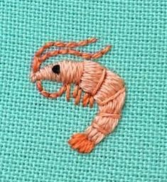 a close up of a piece of cloth with thread on it and an embroidered shrimp