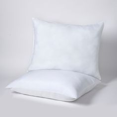 a white pillow and some pillows on a gray background