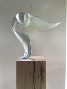 a white sculpture sitting on top of a wooden block