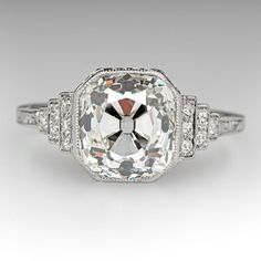 an antique style diamond ring with two sidestones