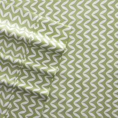 the green and white fabric is folded on top of each other, with an interesting pattern