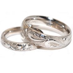 two silver wedding rings sitting next to each other